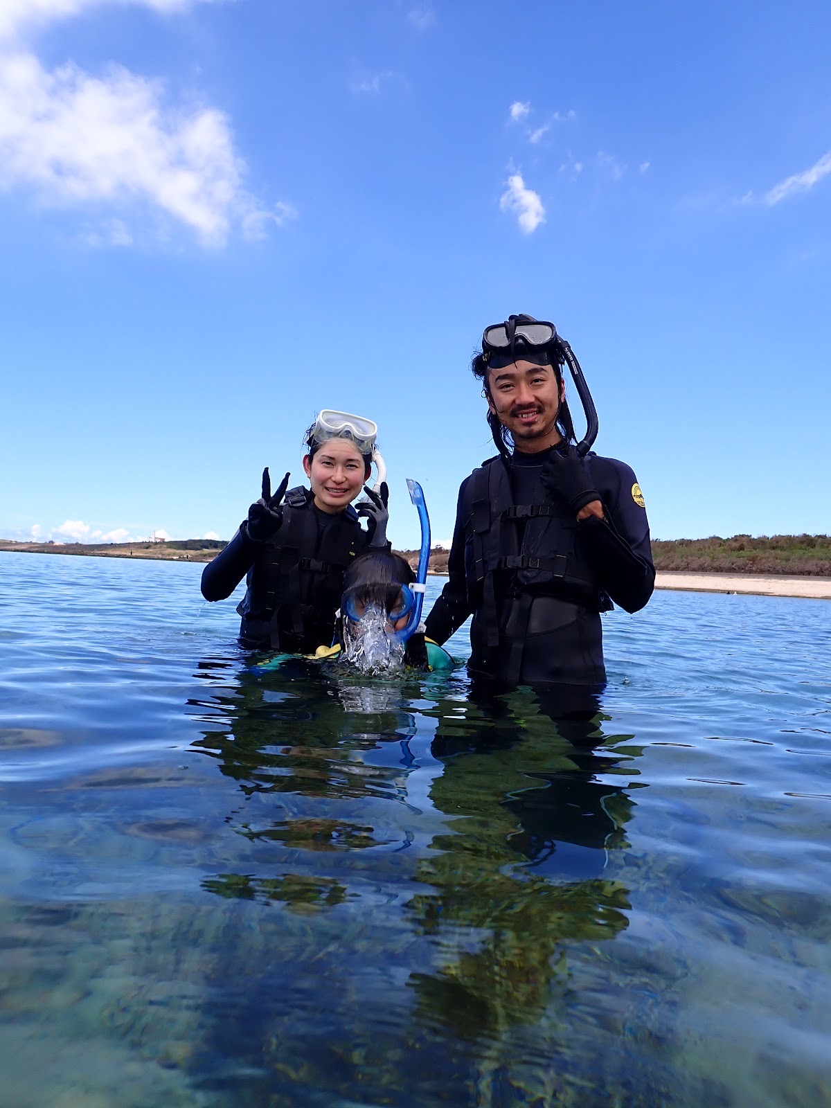 過去のツアーで撮影した水面で笑顔を見せる夫婦と小さなガイド