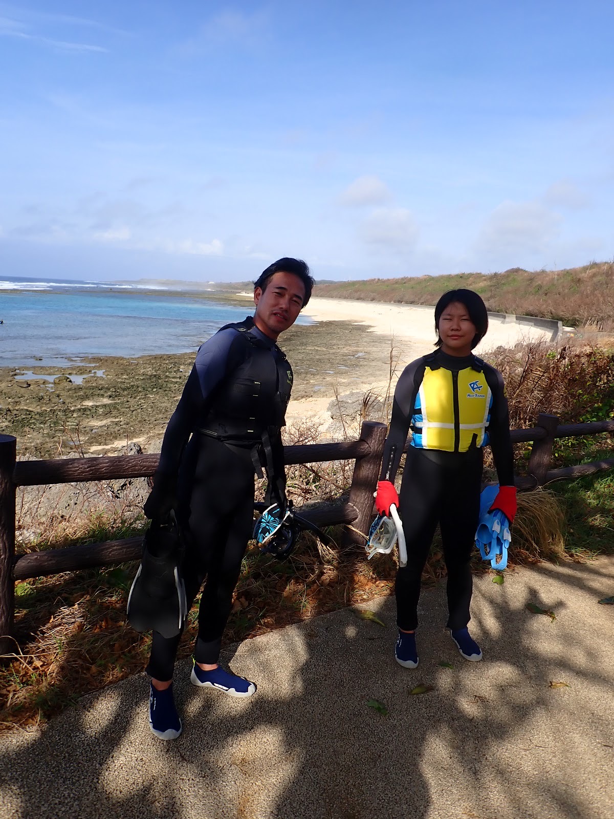 青い海を背景に笑顔を見せるお客様のグループ