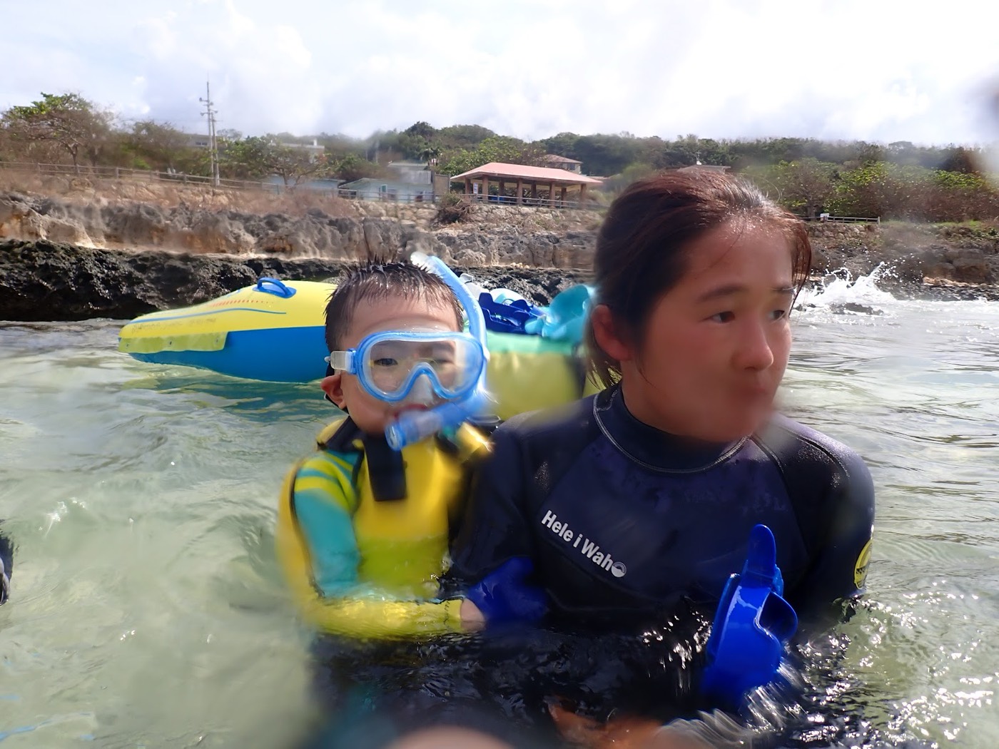 浅瀬の海に入り、ガイドと共に器材の使い方を練習するお子様の様子