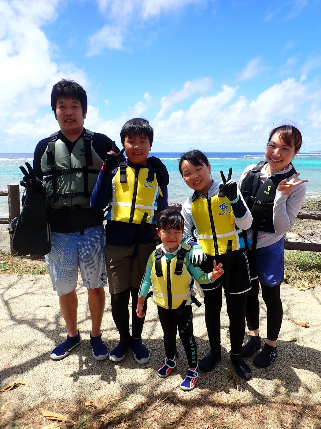 天然水族感で紹介する、海岸でライフジャケットを着用し、準備する『』の参加者たち