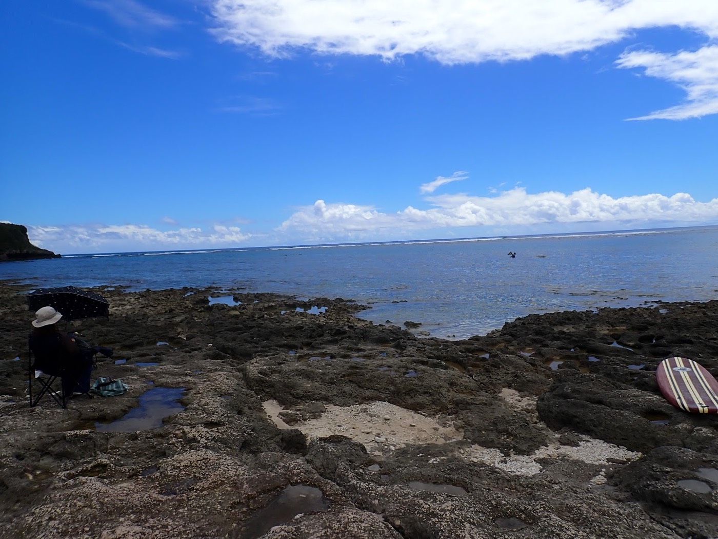 岩場に椅子を置き穏やかな海を眺める天然水族感のある海岸風景