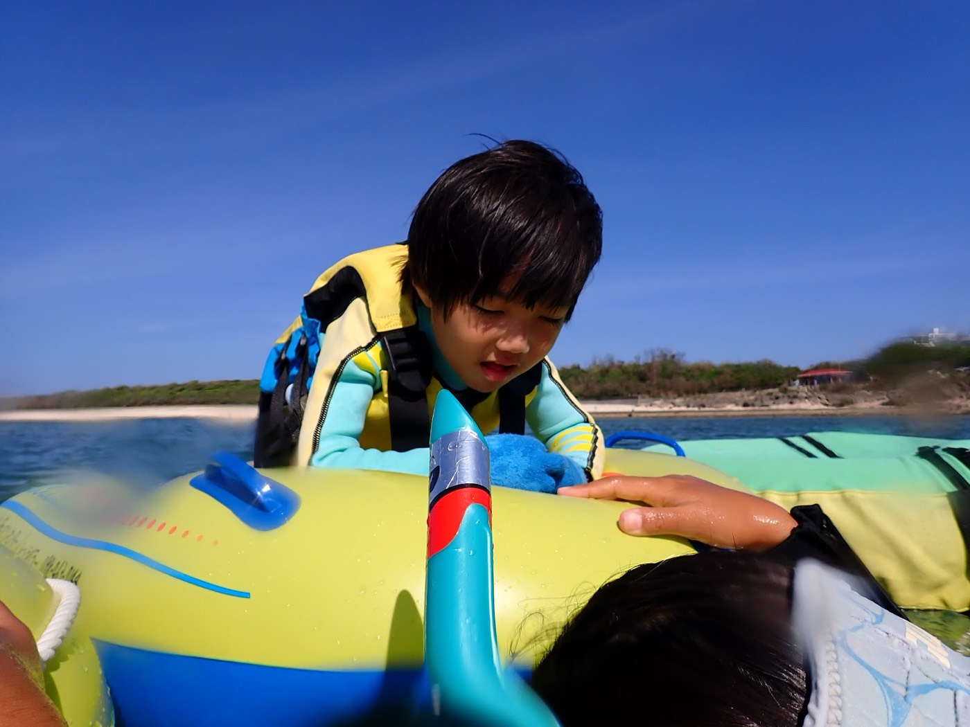 浮具につかまりながら水中の様子を覗き込む小さなお子様