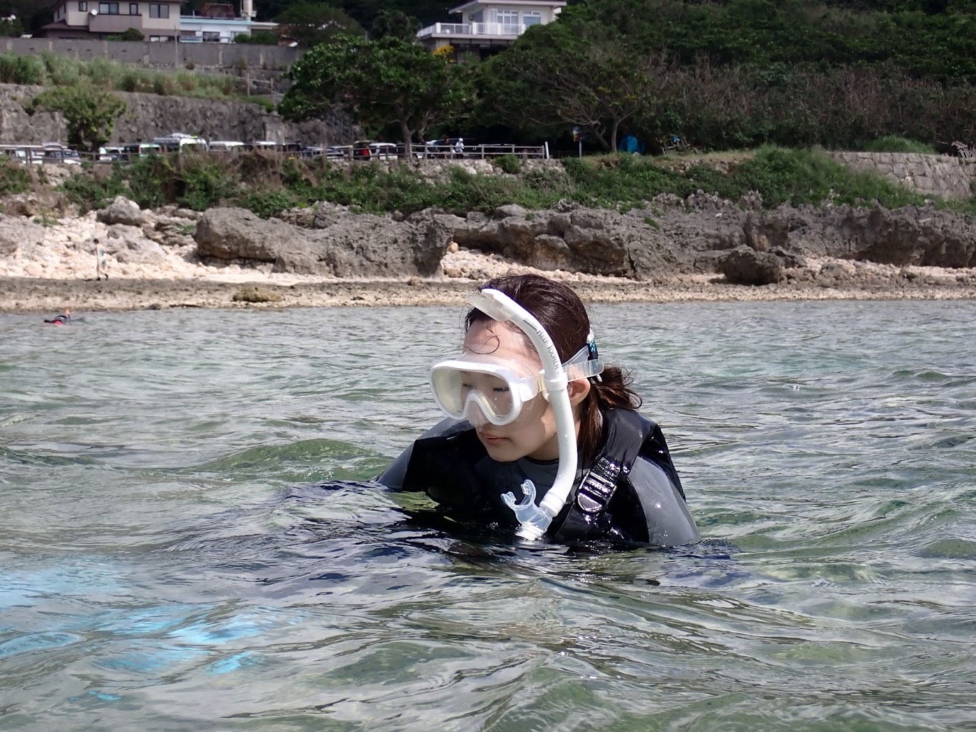 浅瀬でウェットスーツとシュノーケルを装着し、水に慣れている女性参加者