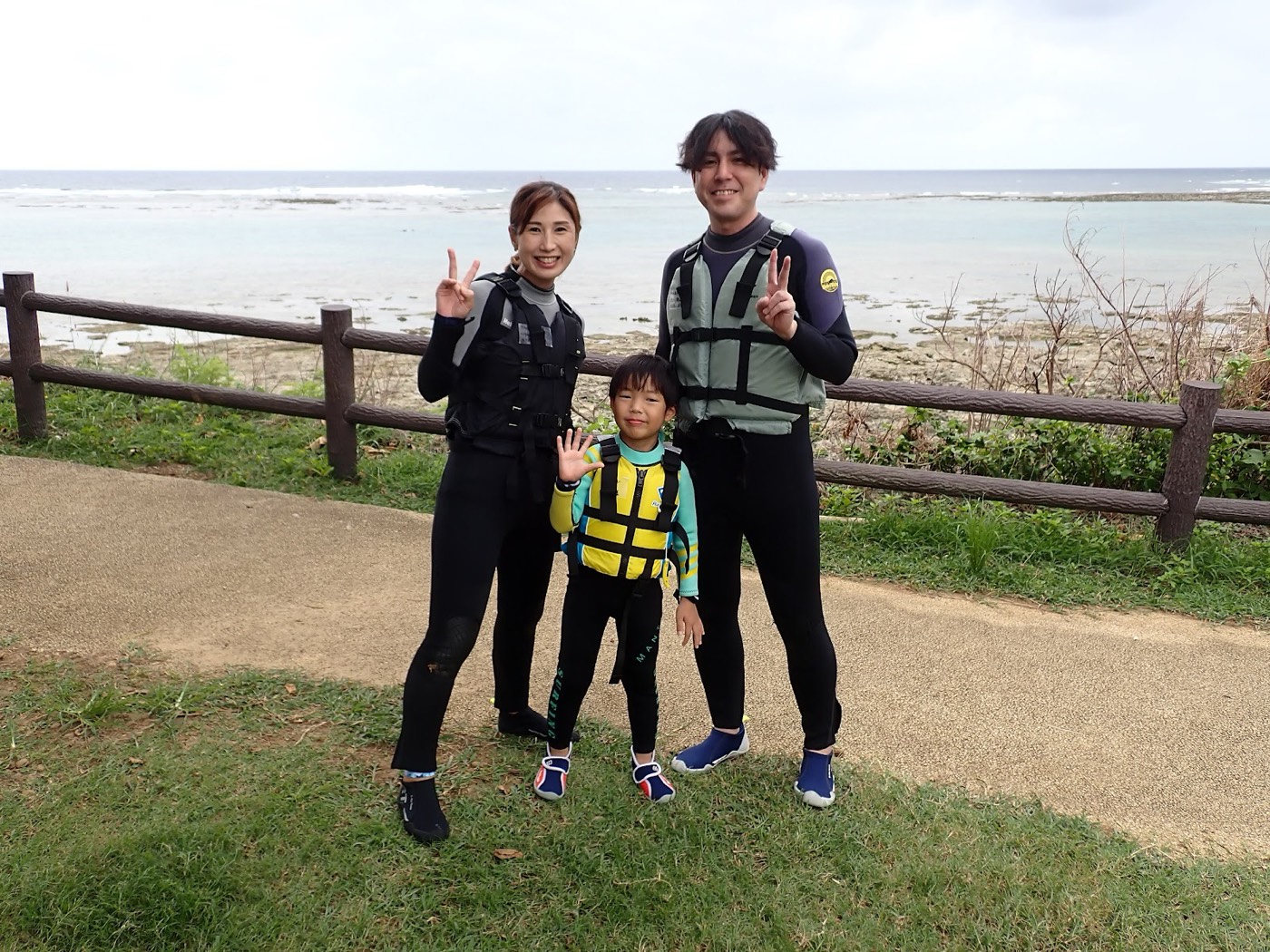 海岸を背景にピースサインをする参加者たち